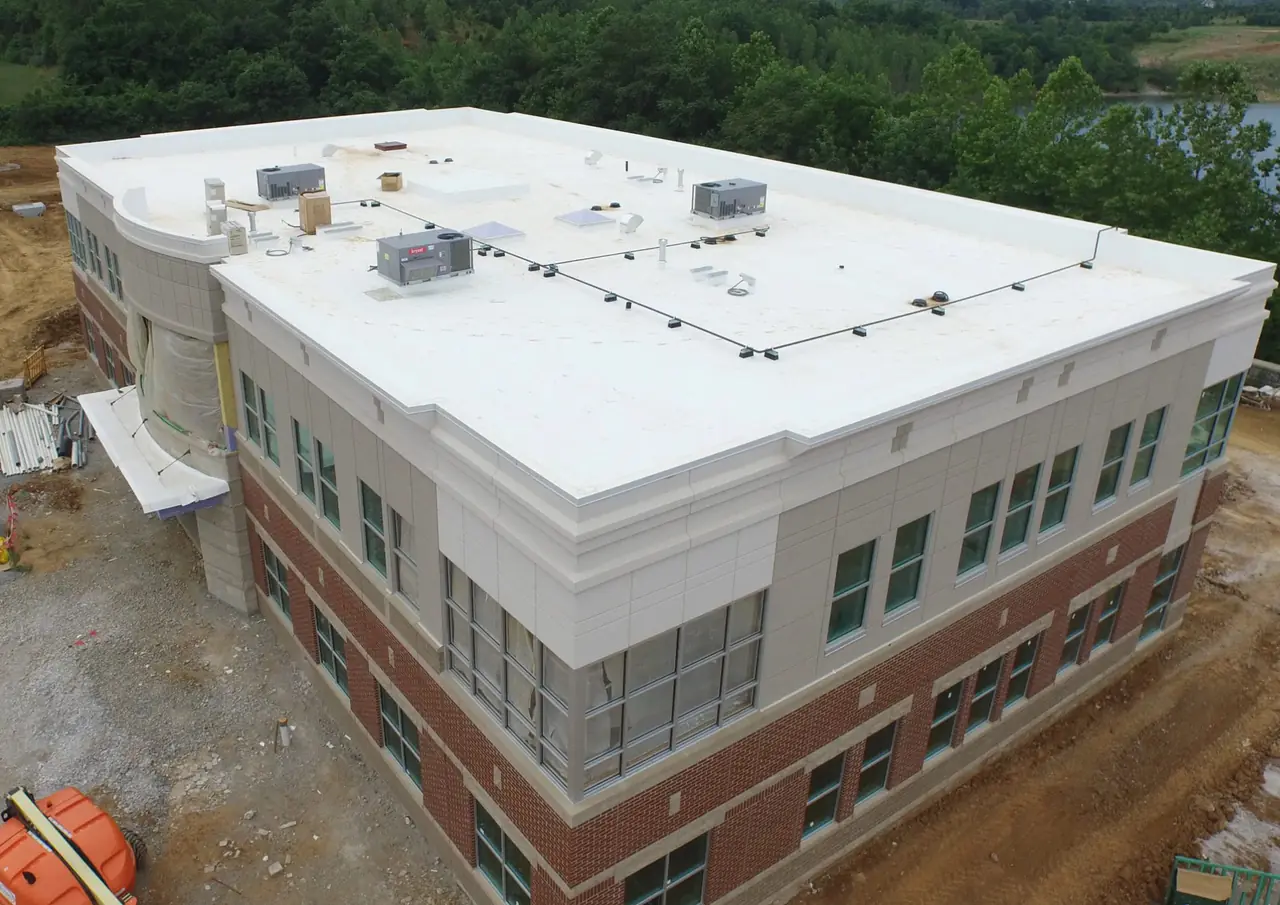 Aerial view of a commercial building with a white waterproofed flat roof and rooftop air-conditioning units