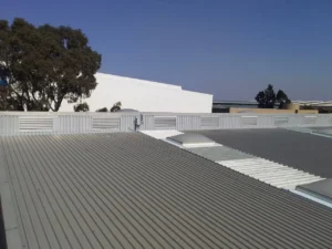 Completed headwall flashing on a corrugated metal roof with skylights