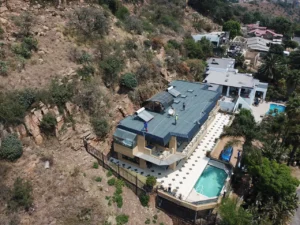 Aerial view of a hillside house with a newly waterproofed flat roof