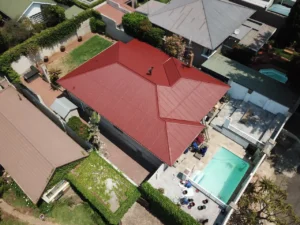 Aerial view of a red waterproofed house roof among neighbouring properties