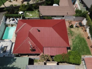 Aerial view of a completed red waterproofed roof next to a swimming pool