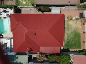 Top-down aerial view of a completed red waterproofed roof
