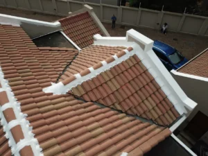 Tiled roof with ridges and parapet walls sealed in white waterproofing